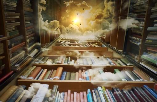 Książki na wysokich regałach. Nad regałami widoczne niebo z chmurami.