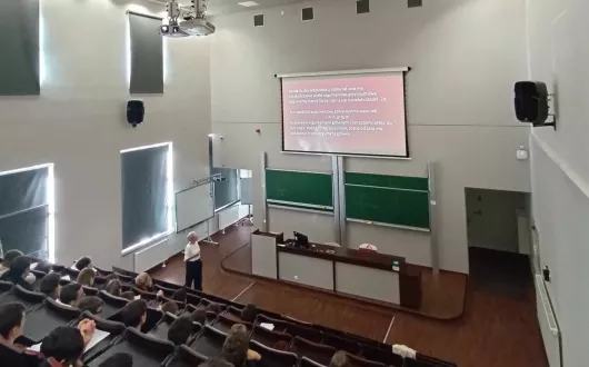 Aula podczas wykładu, na którym kobieta jest prelegentem.