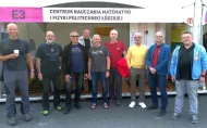 Kilku mężczyzn stojący pod napisem Centrum Nauczania Matematyki i Fizyki Politechniki Łódzkiej.
